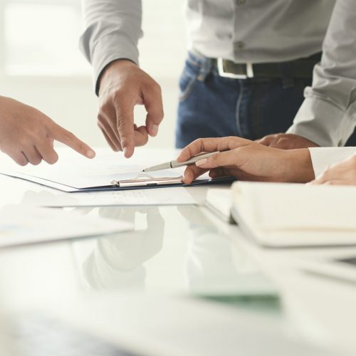 Close-up image of business people pointing at document