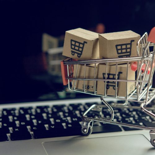 Shopping online concept - Parcel or Paper cartons with a shopping cart logo in a trolley on a laptop keyboard. Shopping service on The online web. offers home delivery.
